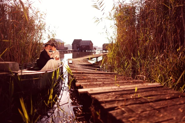 Bride and groom in a boat — Stock Photo, Image