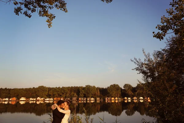 Bride and groom near lake — Stock Photo, Image