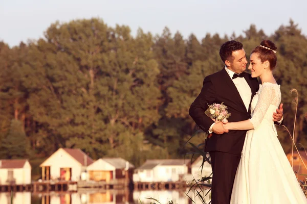 Bruid en bruidegom in de buurt van lake — Stockfoto