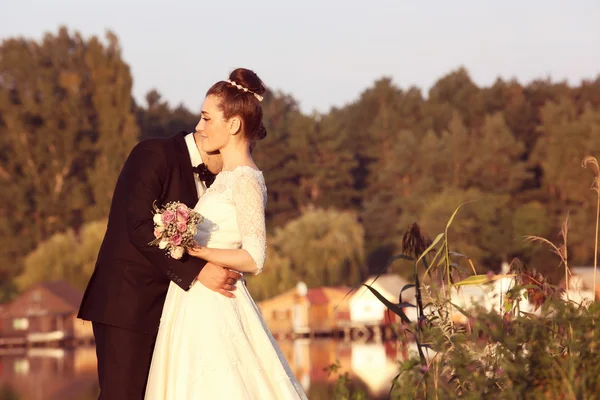 Bride and groom near lake — Stock Photo, Image