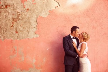 Gelin ve damat öpüşme renkli duvara karşı