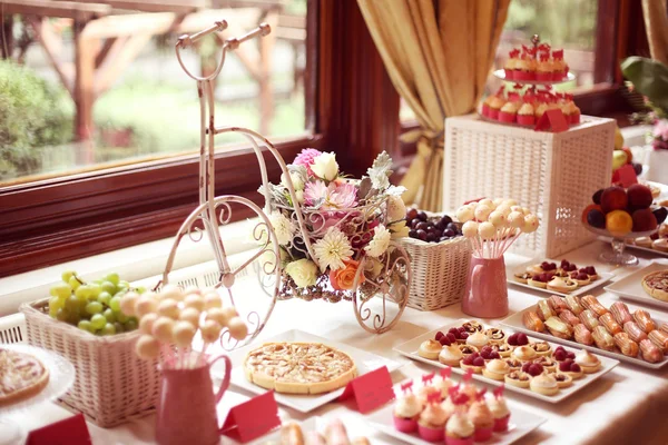 Table setting with flowers and sweets — Stock Photo, Image