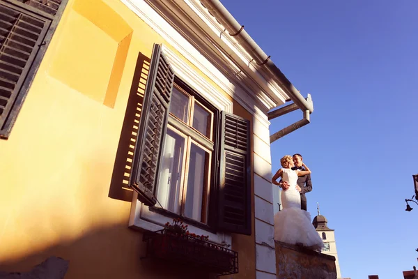 Bride and groom near yellow house — Stock Photo, Image