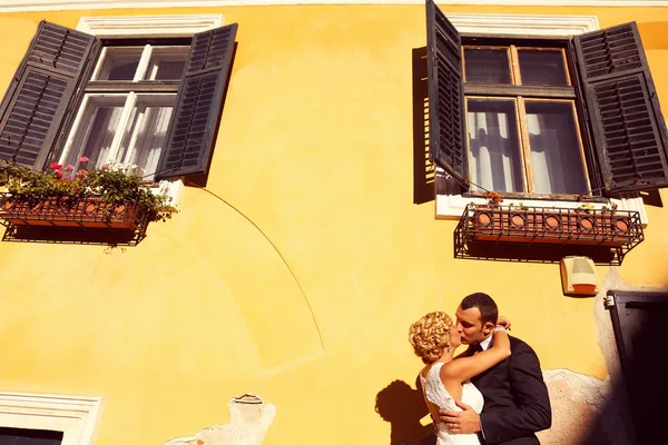 Bride and groom near yellow house — Stock Photo, Image