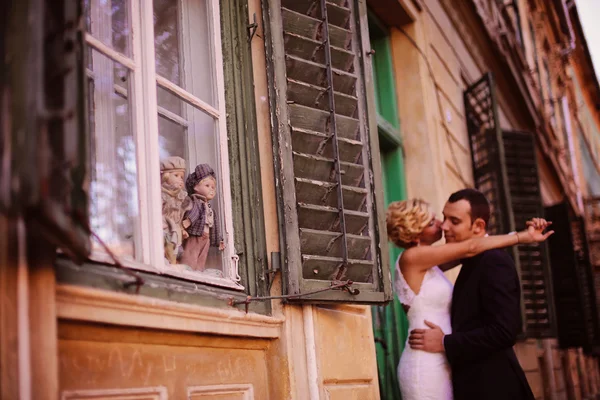 Наречена і наречений обіймаються біля вікна — стокове фото