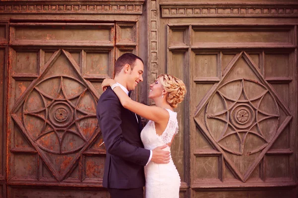 Bride and groom embracing near door — Stock Photo, Image