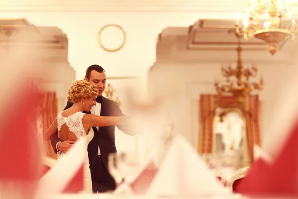 Bruid en bruidegom dansen in lege restaurant — Stockfoto