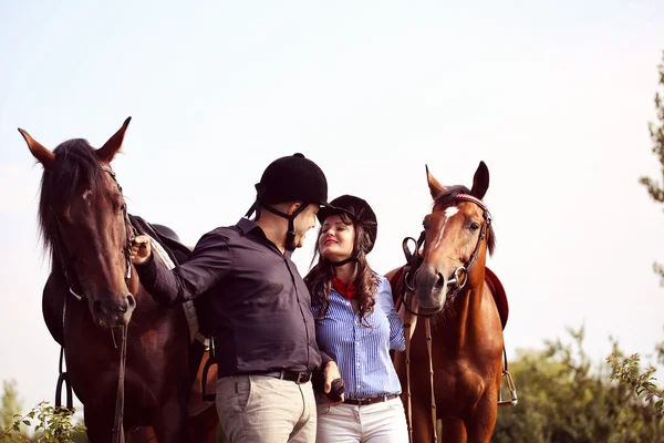 Glückliches Paar mit zwei Pferden — Stockfoto