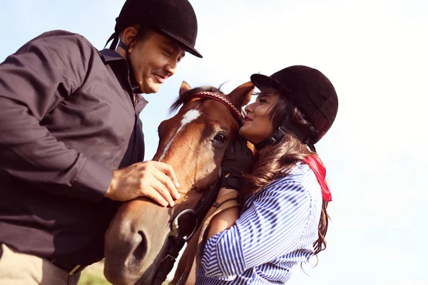 Paar spielt mit einem Pferd — Stockfoto