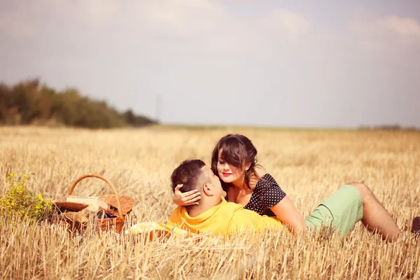 Casal nos campos fazendo piquenique — Fotografia de Stock