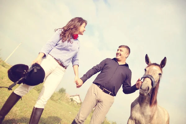 Happy couple with their horse — Stock Photo, Image