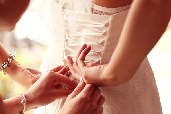 Mãos ajudando a noiva com o vestido de noiva — Fotografia de Stock