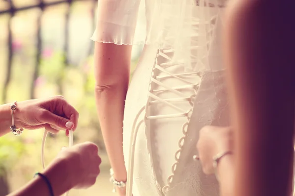 Mãos ajudando a noiva com o vestido de noiva — Fotografia de Stock