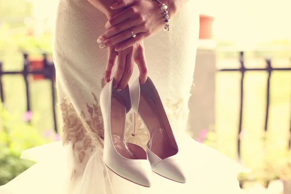 Bride holding her shoes — Stock Photo, Image