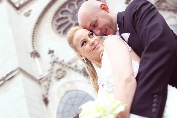 Noiva e noivo em frente à igreja — Fotografia de Stock