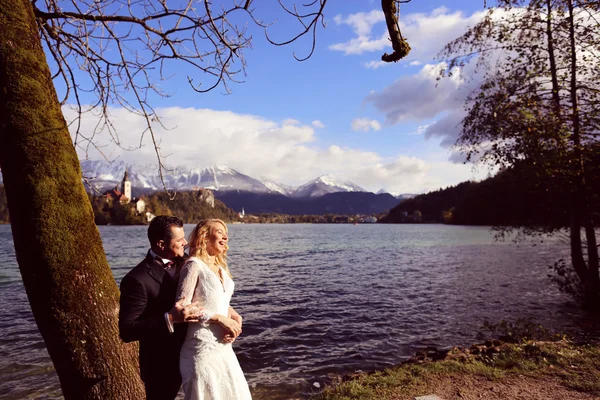 Наречений і наречений обіймаються біля озера — стокове фото