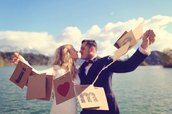 Bride and groom playing with Just Married cards — Stock Photo, Image