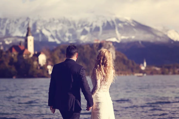 Noiva e noivo abraçando perto do lago Bled — Fotografia de Stock