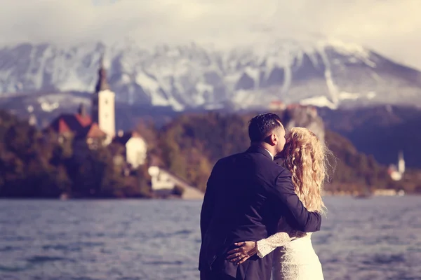 Νύφη και ο γαμπρός αγκαλιάζοντας κοντά σε Bled lake — Φωτογραφία Αρχείου