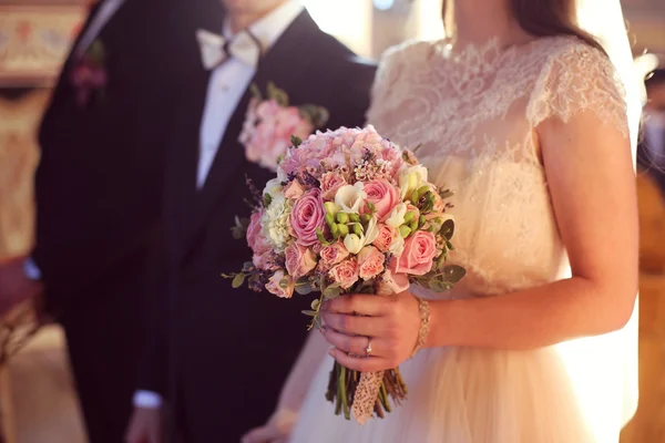 Sposa tenendo il suo bouquet di nozze in chiesa — Foto Stock