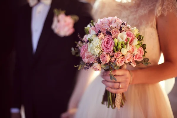 Невеста держит свадебный букет в церкви — стоковое фото