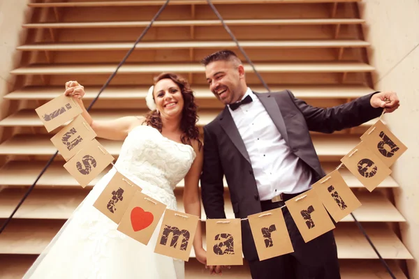 Bride and groom holding Just Married signs — Stock Photo, Image