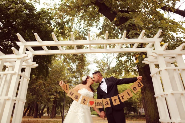 Bruden och brudgummen håller Just Married tecken — Stockfoto