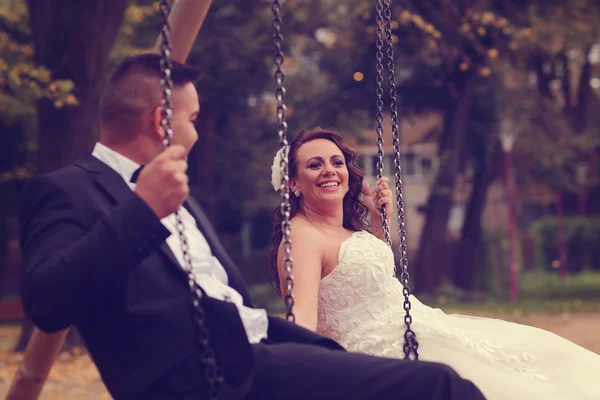 Bruden och brudgummen i en gunga — Stockfoto