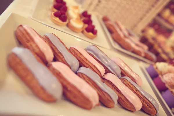 Pink and blue cream on eclairs — Stock Photo, Image