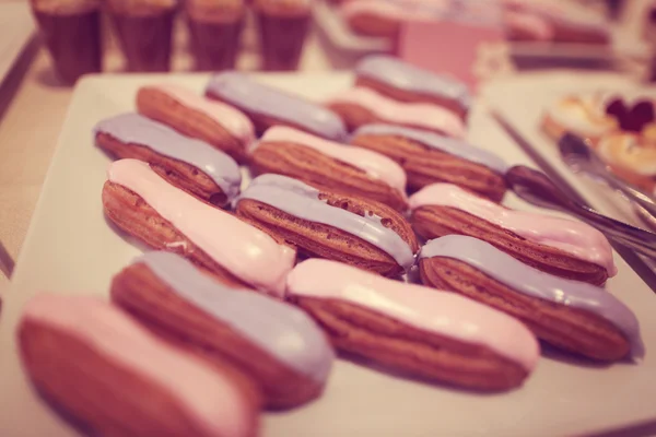 Roze en blauw crème op eclairs — Stockfoto