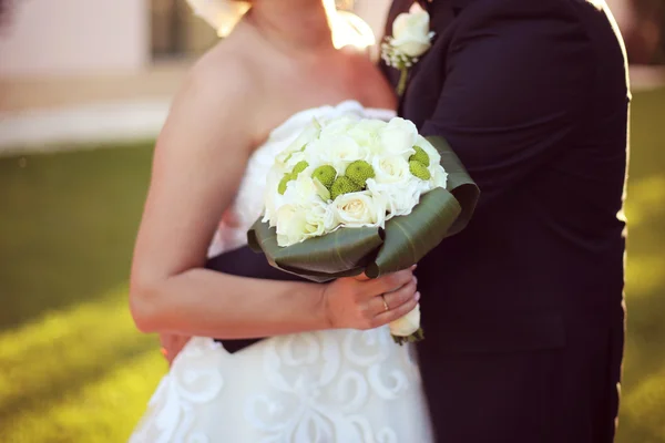 Noiva e noivo segurando e um buquê de casamento — Fotografia de Stock