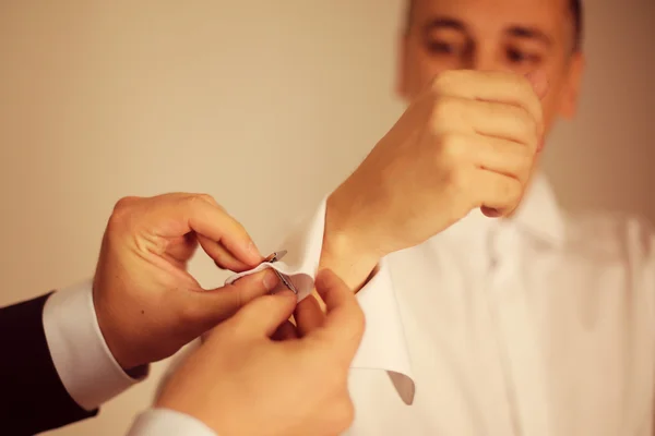 Hands helping the groom with the cuff lings — Stock Photo, Image