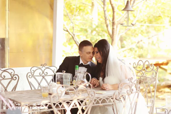 Novia y novio sentados en la mesa — Foto de Stock