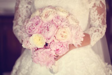 Eller peonies buket tutan bir gelin