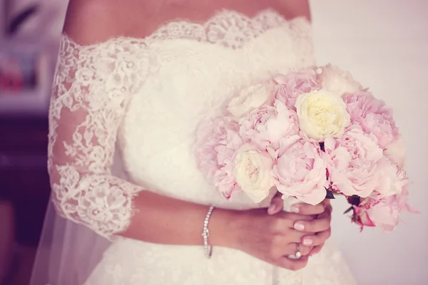 Mãos de uma noiva segurando buquê de peônias — Fotografia de Stock