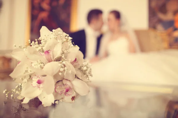 Bouquet de lírio na mesa com noiva e noivo como silhuetas — Fotografia de Stock