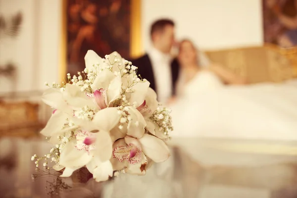 Bouquet di giglio sul tavolo con sposa e sposo come silhouette — Foto Stock