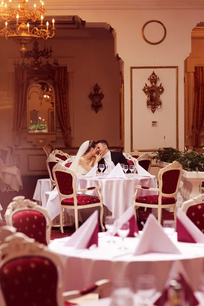 Bruid en bruidegom zittend op tafel — Stockfoto