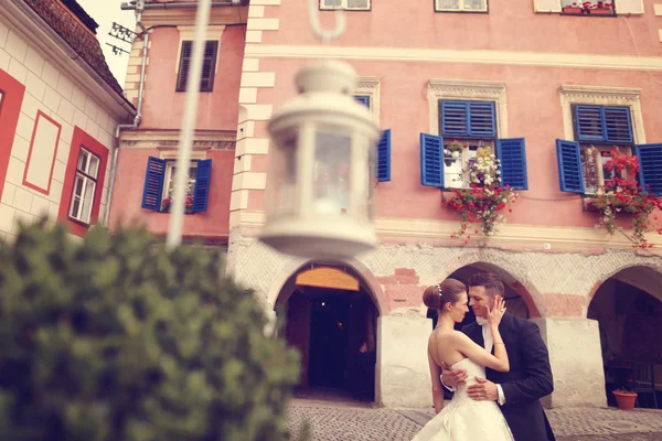 Bruden och brudgummen embracing i staden — Stockfoto