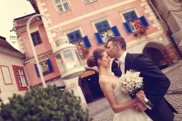 Bruid en bruidegom omarmen in de stad — Stockfoto