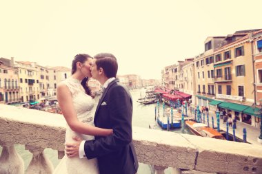 Gelin ve damat bir köprüde öpüşme