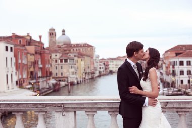 Gelin ve damat bir köprüde öpüşme