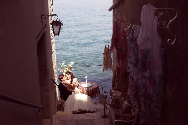 Невеста и жених целуются у океана — стоковое фото