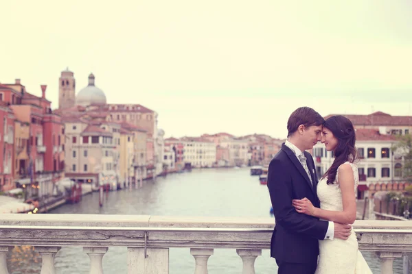 Mariée et marié baisers sur un pont — Photo