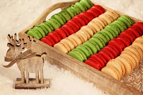 Red and green macaroons on wooden plate — Stock Photo, Image