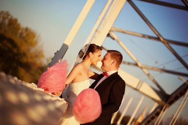 Bride and groom holding a candy floss — Stock Photo, Image