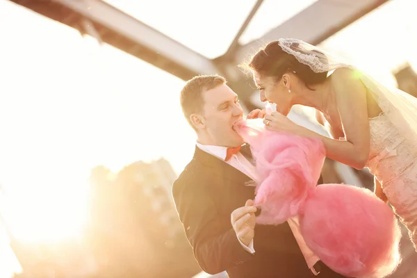 Bride and groom holding a candy floss — Stock Photo, Image