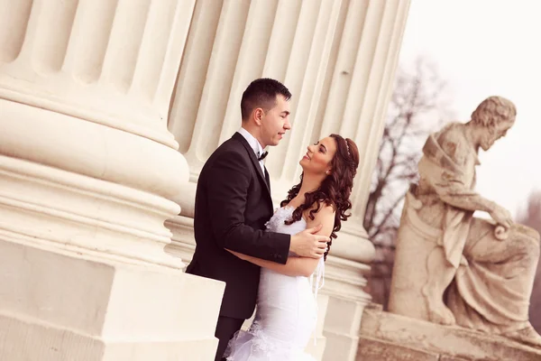 Bride and groom near white columns — Stock Photo, Image