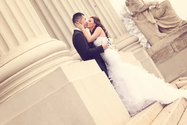 Nevěsta a ženich poblíž bílé sloupce — Stock fotografie