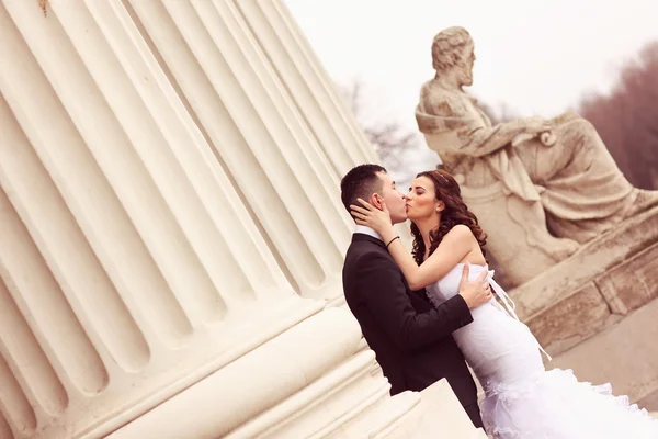 Noiva e noivo perto de colunas brancas — Fotografia de Stock